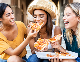 women eating pizza