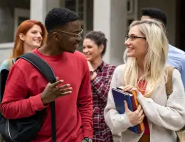 two young adults walking outside and talking